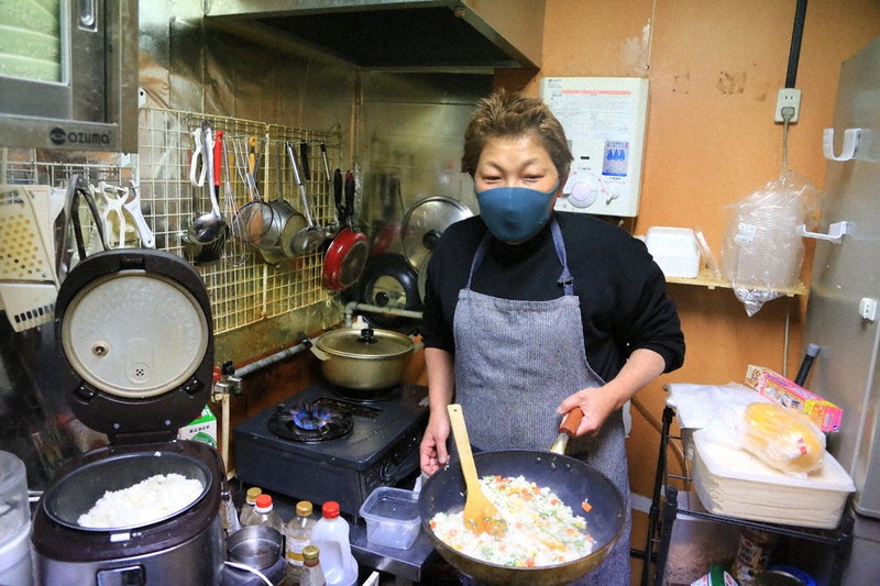 「ごはん処 おかえり」で人気の焼きめしを炒める上野敏子さん=大阪府豊中市庄内西町3で22日、村松洋撮影