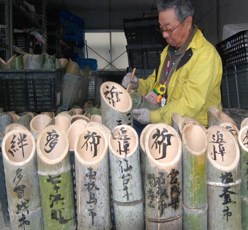 竹灯籠にメッセージを書き込む山川泰宏さん=神戸市灘区の摩耶埠頭公園で、2012年撮影