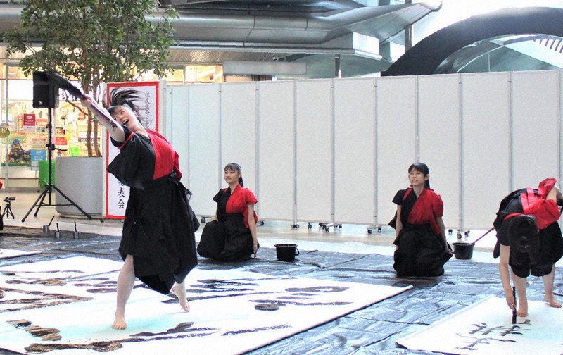 音楽に合わせて踊りながら力強い書を披露した上宮高書道パフォーマンス部の部員ら=大阪市中央区のツイン21で2020年12月22日13時5分、山本夏美代撮影