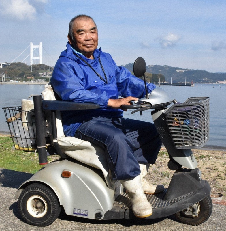 日課の清掃を終え、愛車のスクーターに乗る東山さん=香川県坂出市の櫃石島で2020年11月26日午前10時32分、川原聖史撮影