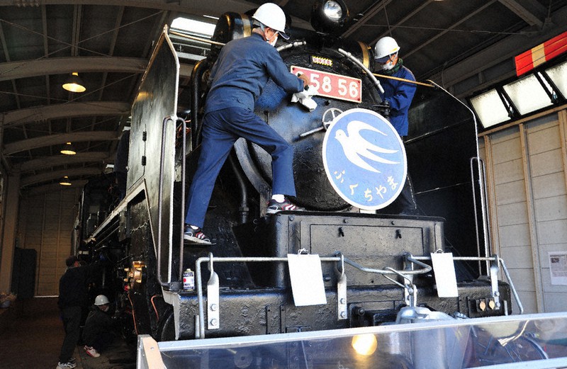 蒸気機関車を隅々まで丁寧に磨く保存会の役員ら=福知山市菱屋で2020年12月28日午前9時41分、佐藤孝治撮影