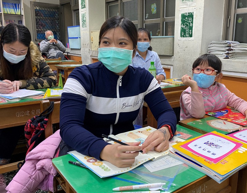 建安小では週3回、夜に多国籍の人々が中国語を学ぶ。ベトナム出身のリンさん(手前左)は、長女の氏玲ちゃん(同右)と一緒に授業を受けている=台北市の建安小学校で2020年12月4日午後8時28分、福岡静哉撮影