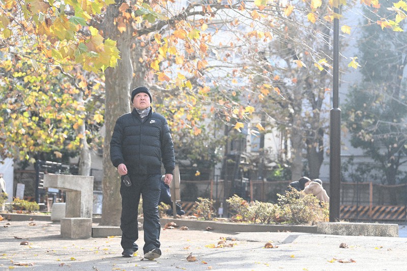 普段生活する簡易宿泊所近くの公園を歩く孝志さん。仕事や住み家が見つかったら、母に会いに行くかもしれない=東京都新宿区で、大西岳彦撮影