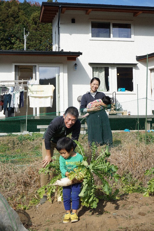 収穫したばかりのダイコンに笑顔の田中さん一家=埼玉県飯能市南高麗地区で2020年12月12日、清藤天撮影