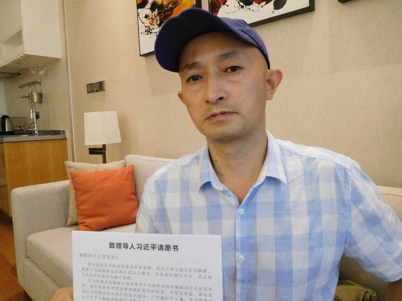新型コロナで父を亡くした張海さん。習近平国家主席宛ての「請願書」を手に「感染爆発につながった情報隠しの責任を追及すべきだ」と訴えた=広東省深圳で2020年11月