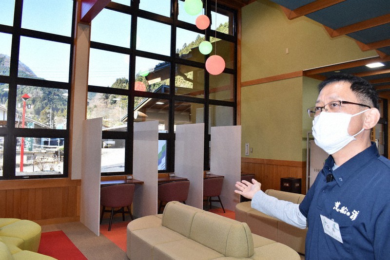 ロビーの一角に設けられたコワーキングスペースを案内する中島功副館長=群馬県下仁田町南野牧の「荒船の湯」で2020年112月1日、鈴木敦子撮影