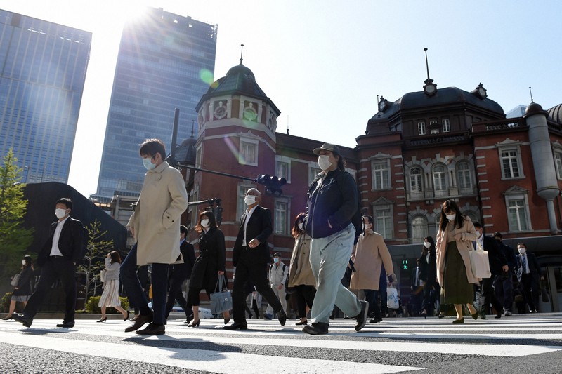 昨年の緊急事態宣言中、マスクをつけて通勤する人たち=東京都千代田区で2020年4月15日午前8時21分、北山夏帆撮影