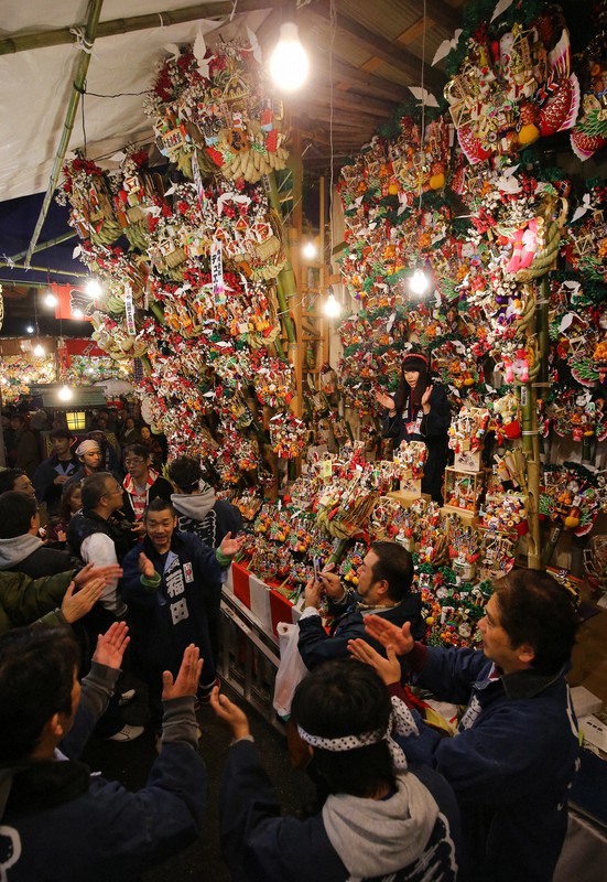 縁起物のくま手が売れるたびに威勢のいいかけ声とともに祝いの手締めが響き渡った酉の市=東京都台東区の鷲神社で2014年11月10日午前0時17分、長谷川直亮撮影