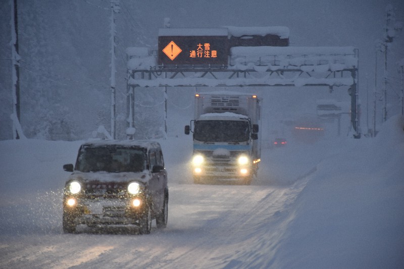 「大雪通行注意」の表示が出された道路を走行する車=秋田県湯沢市で2021年1月2日午後4時33分、高野裕士撮影