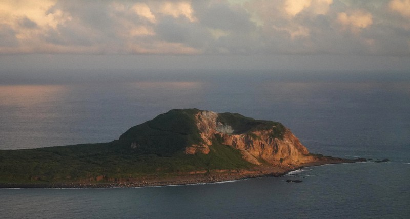 夕日に染まる摺鉢山。米軍の激しい砲爆撃で、山の形が変わったとされる=東京都小笠原村の硫黄島で2020年10月24日午後4時52分(代表撮影)