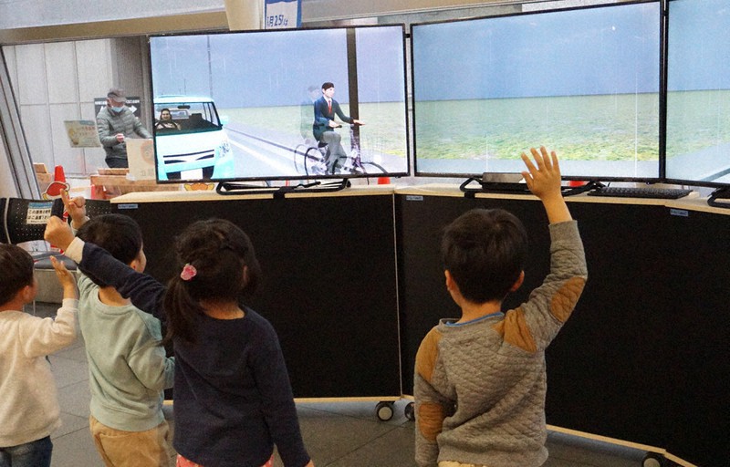 手を上げて道路横断を疑似体験する子どもたち=埼玉県所沢市元町で2020年12月8日、清藤天撮影