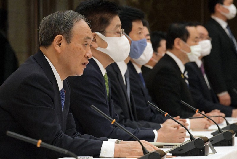 新型コロナウイルス感染症対策本部の会合で「緊急事態宣言」を再発令を宣言する菅義偉首相(左)=首相官邸で2021年1月7日午後5時半、竹内幹撮影