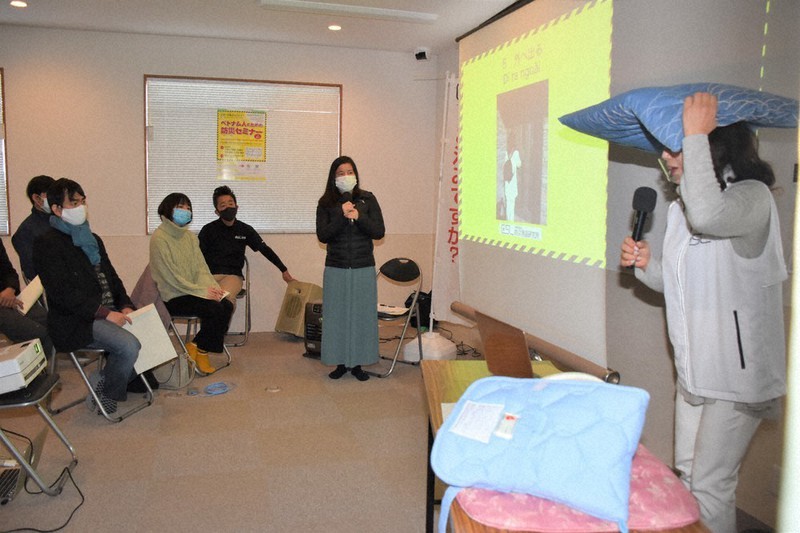 頭を守って逃げるよう説明を受けるベトナム人ら=和歌山市雑賀崎で、木原真希撮影
