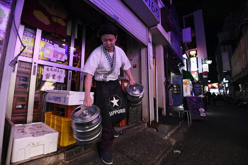 緊急事態宣言を受けて午後8時で閉店した居酒屋の店長。飲食店が集まる一帯はこの時間で閑散としていた=東京都新宿区で2021年1月8日午後8時10分、滝川大貴撮影