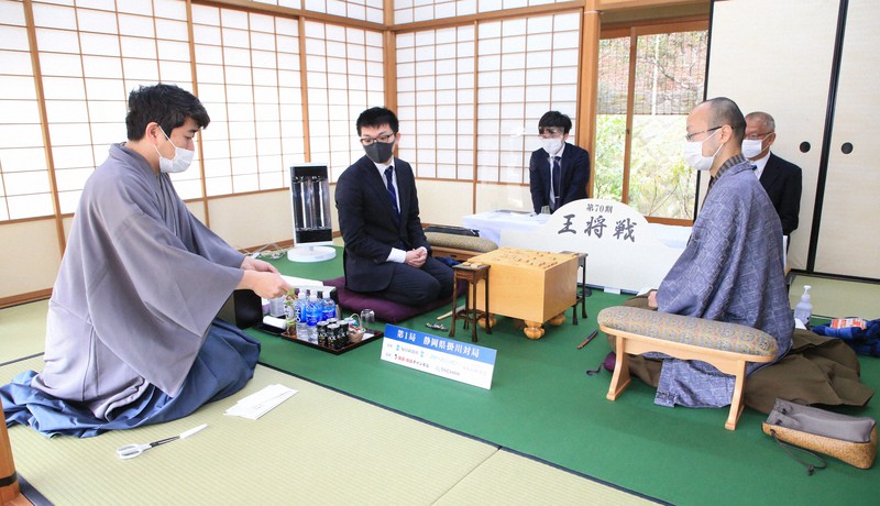 第70期王将戦第1局第2日目、渡辺明王将(右)と永瀬拓矢王座(左から2人目)に封じ手を読み上げる立会人の森内俊之九段(左)=静岡県掛川市の掛川城二の丸茶室で2021年1月11日(代表撮影)