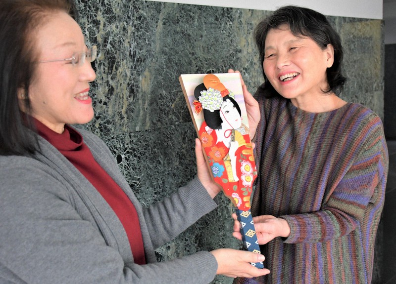 修復を終えた押し絵羽子板を受け取る畠中寿子さん(右)と修復した磯部崇子さん=滋賀県守山市守山5で2020年12月14日午前11時15分、礒野健一撮影