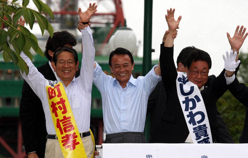 2009年の衆院選の街頭演説会で町村信孝氏(左)とともに、麻生太郎首相(当時、中央)の応援を受ける吉川貴盛氏(右)=札幌市中央区の大通公園で、近藤卓資撮影