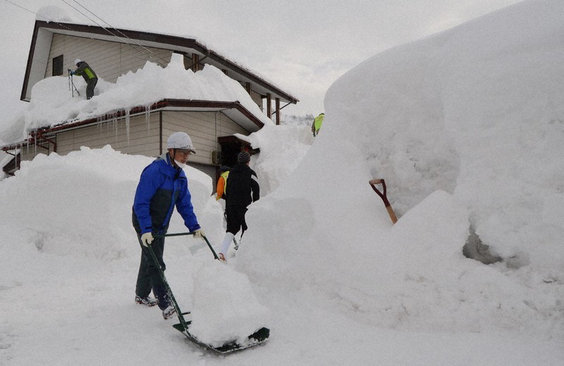雪を片付ける除雪ボランティア=新潟県南魚沼市内で、板鼻幸雄撮影