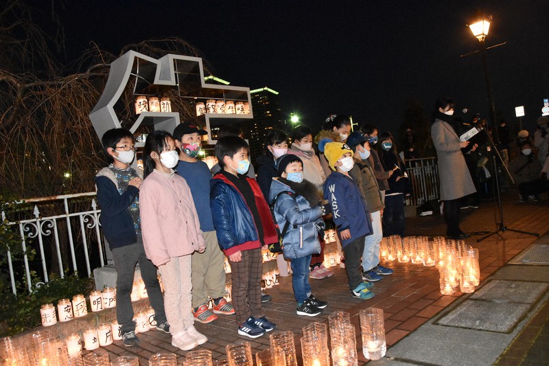 「生」のモニュメントの前で、阪神大震災の犠牲者に、追悼の祈りをささげる子供たち=兵庫県宝塚市内で2021年1月16日午後5時47分、土居和弘撮影