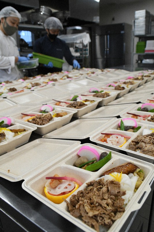 おせち料理をイメージした「2021新春弁当」を盛り付けるシェフたち=東京都江東区豊洲6で