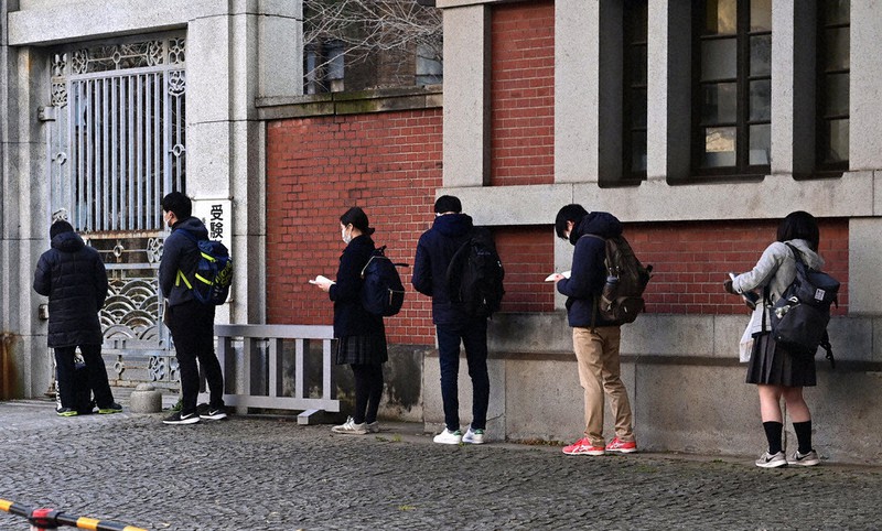 大学入学共通テストの会場前で、間隔を空けて開門を待つ受験生ら=東京都文京区の東京大で16日午前7時52分、北山夏帆撮影