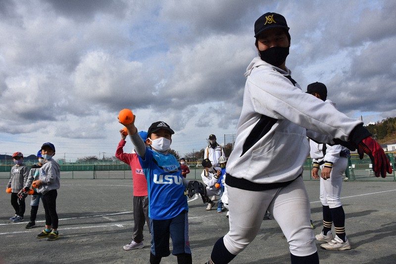 子どもたちにボールの投げ方を指導する三島南の選手=静岡県三島市内で2020年12月19日、岸本悠撮影