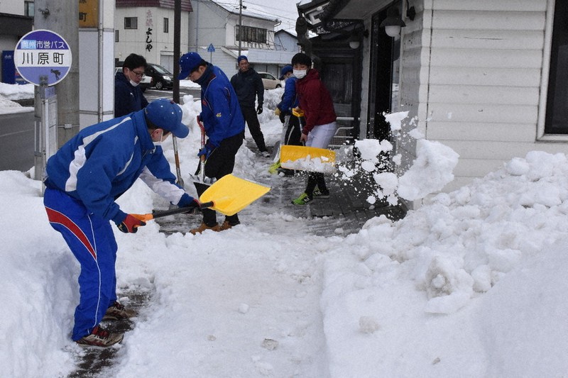 除雪作業に取り組むオール江刺の選手ら=岩手県奥州市江刺川原町で