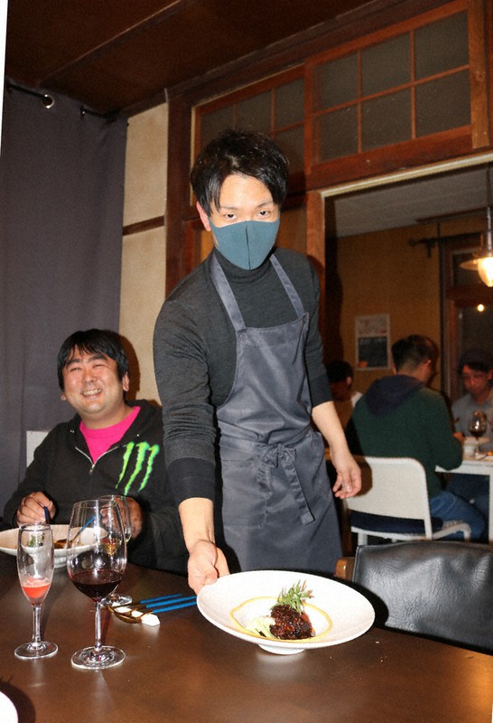 得意の仏料理とワインで来客をもてなす村上さん(右)