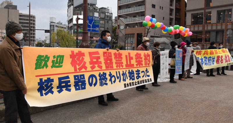 横断幕を掲げて核禁条約発効を歓迎する県原水協メンバー