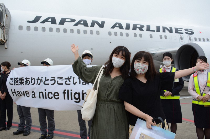 搭乗前、日本航空の機体を背景にポーズを取る遊覧飛行の旅客=成田空港で2020年9月26日午後4時14分、中村宰和撮影