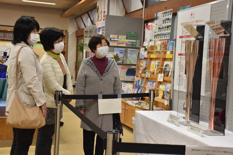 県庁で展示された(左から)オリンピックとパラリンピックの聖火リレートーチを眺める来場者=県庁で、松原由佳撮影