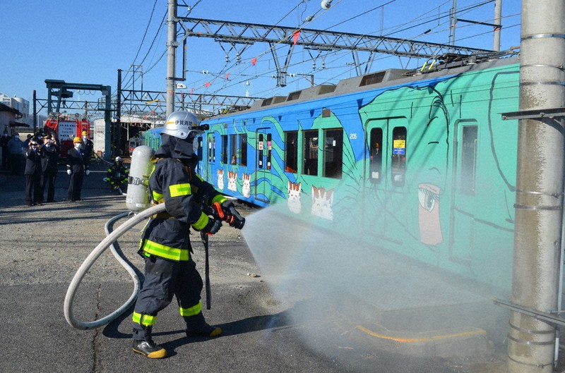 合同訓練で車両に放水する伊賀消防署員=三重県伊賀市の上野市駅構内で、大西康裕撮影