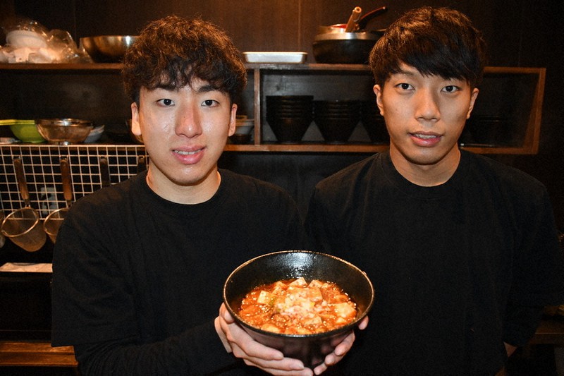 メインメニューの「シセンマーボードウフラーメン」を持つ代表の西さん(左)と料理長の奥野さん=奈良市で、小宅洋介撮影