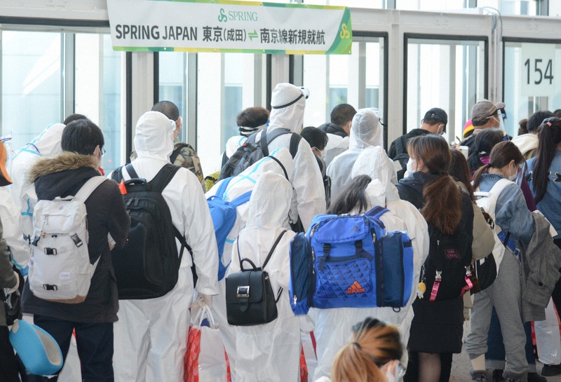 南京行きの初便の搭乗口に並ぶ旅客。一部は防護服を着ていた=成田空港で2021年1月22日午前10時16分、中村宰和撮影