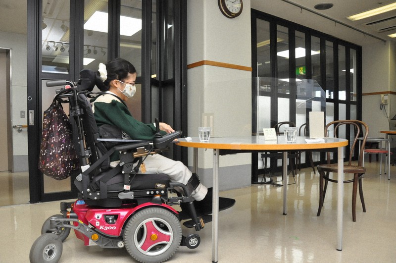 電動車いすで飲食店の席に着く岩崎花奈絵さん。店内と外に段差がなく、いすが固定でないため利用しやすい=東京都武蔵野市で2021年1月21日午後1時48分、五十嵐朋子撮影