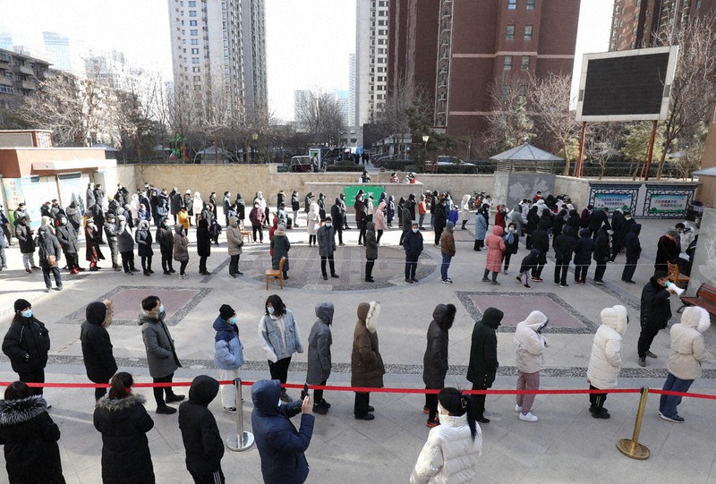 新型コロナウイルス対策のため封鎖措置が取られている中国河北省石家荘市の天滋嘉鯉社区で、PCR検査のために並ぶ住民=1月6日、新華社