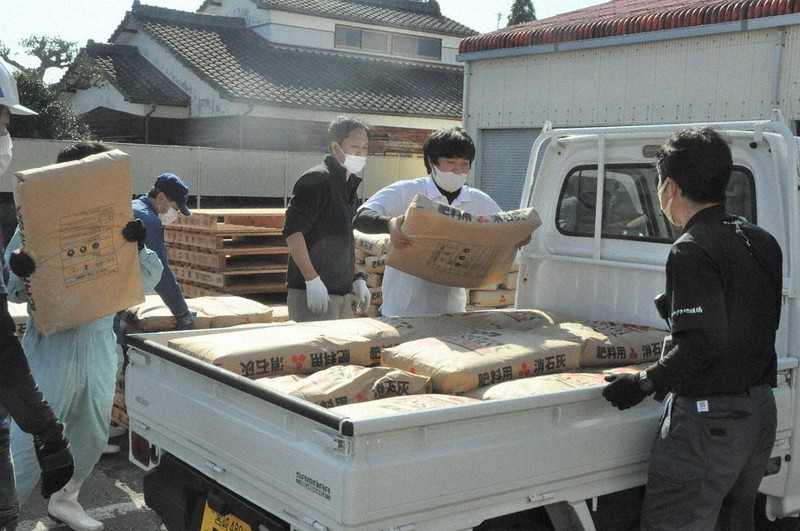 消石灰を軽トラックの荷台に積み込む関係者
