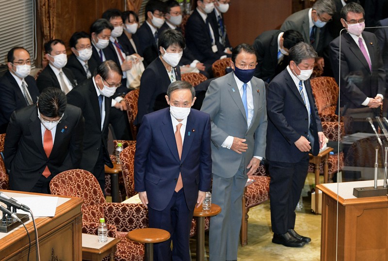 参院予算委員会で2020年度第3次補正予算案が賛成多数で可決され、一礼する菅義偉首相(中央)と閣僚ら=国会内で2021年1月28日午後5時22分、竹内幹撮影