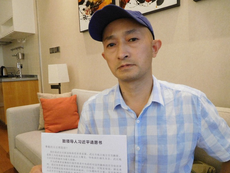 新型コロナで父を亡くした張海さん。習近平国家主席宛ての「請願書」を手に「感染爆発につながった情報隠しの責任を追及すべきだ」と訴えた=中国広東省深圳で2020年11月27日、河津啓介撮影