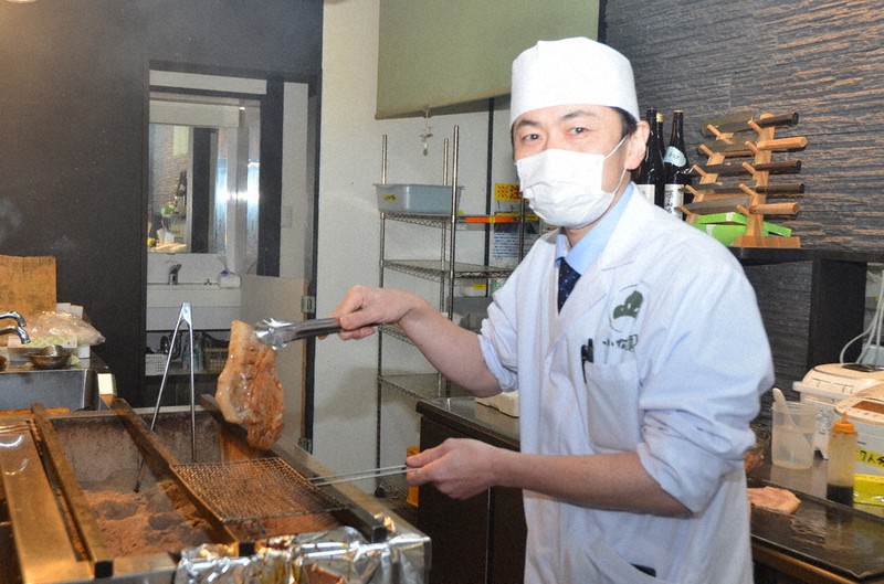 試作品を作るため、ウナギの焼き台で豚ロースをかば焼きにする小倉清暢さん=茨城県古河市鴻巣で2021年1月28日午後6時48分、安味伸一撮影