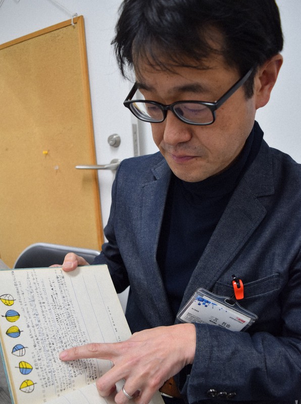 母親が記録した育児日記を手に、次世代調査に親が関わる必要性を訴える2世の認定患者、三苫哲也さん=福岡市博多区で、2021年1月30日午後4時27分、青木絵美撮影