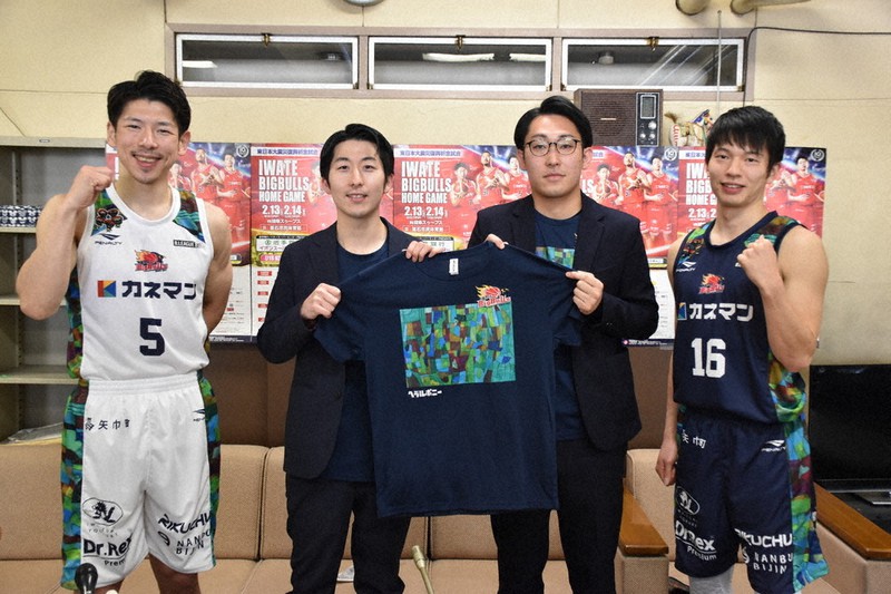 特別Tシャツを持ったヘラルボニーの松田文登副社長(左から2人目)、ビッグブルズの水野哲志社長(同3人目)と、特別ユニホームを着た選手=盛岡市内丸の県庁で