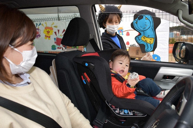 ドライブスルー方式豆まきを楽しむ親子連れ=茨城県龍ケ崎市貝原塚町のながと夢認定こども園で2021年2月1日、庭木茂視撮影