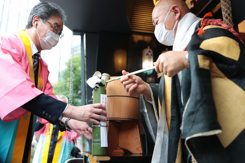 「堂島薬師堂節分お水汲み祭り」で参列者に水を渡す僧侶=大阪市北区で2021年2月2日午後3時17分、小出洋平撮影