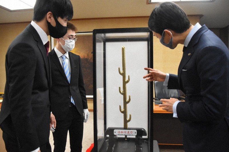 「令和七支刀」を制作した王寺工業高校の卒業生ら=奈良県天理市役所で、広瀬晃子撮影
