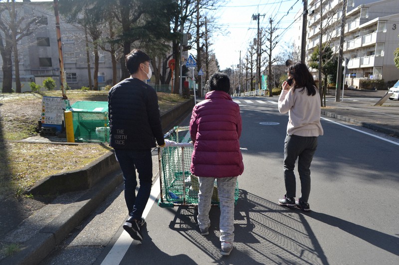 週に数回の古紙回収の作業。支援者と一緒に近くの団地の古紙を回収して回る由美さん(中央)=横浜市で2021年1月29日、上東麻子撮影
