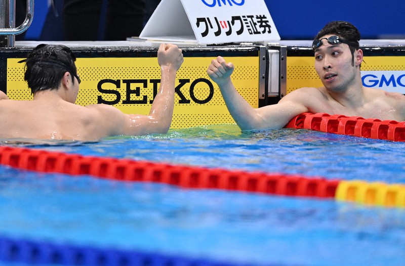 男子200メートル個人メドレー決勝を制した萩野公介(右)と8位に終わった瀬戸大也がグータッチをする=東京アクアティクスセンターで2021年2月6日、宮間俊樹撮影
