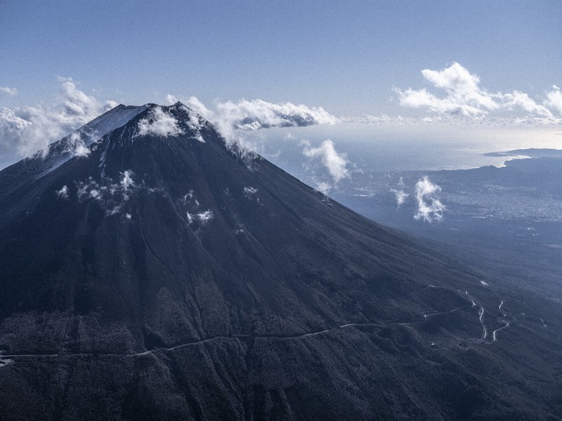 山梨県側から望む富士山。中腹を切り込む線は富士スバルライン=2020年12月25日午後1時46分、本社ヘリから