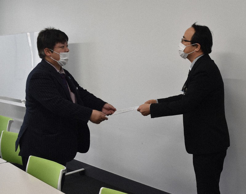 佐賀県の担当者(右)に申し入れ書を手渡す市民団体の代表=佐賀県庁で2021年2月10日午後2時2分、池田美欧撮影
