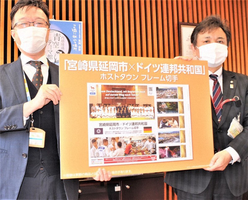 フレーム切手をあしらったパネルを手にする読谷山市長(左)ら